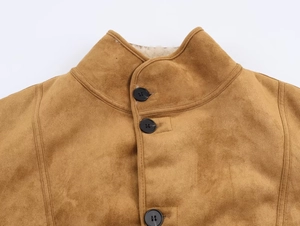 Close-up of brown suede jacket collar with white faux fur lining and black round buttons