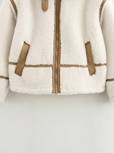 Détail d'une veste en polaire avec bordure en daim marron, fermeture éclair et tissu