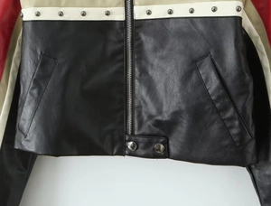 Detail of color-block PU biker jacket with silver stud rivets and metal zipper closure