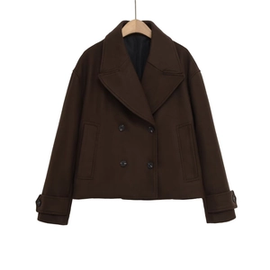 Detail of dark brown double-breasted wool coat featuring classic lapels and black buttons