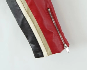 Detail of faux leather jacket sleeve with tricolor panels and silver zipper closure