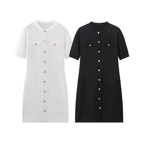 Detail view of knitted short sleeve dresses in black and white with gold buttons