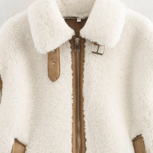 Veste sherpa blanche pour femme avec bordures en daim marron et zip métallique chic