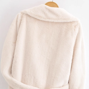 Chic beige faux fur coat for women with wide lapel and soft texture on wooden hanger