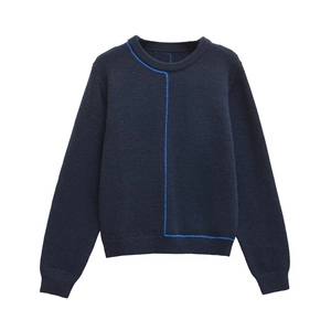 Detail of navy knit sweater featuring bright blue geometric lines and ribbed neckline