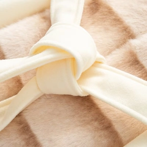 Detailed view of striped faux fur texture and beige tied belt on a midi wool-like coat