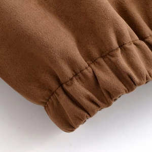Detail of brown faux suede jacket showing elastic hem texture and fine stitching