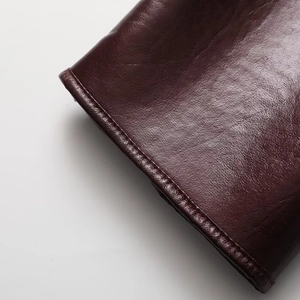 Detail shot of deep burgundy PU leather jacket featuring neat stitching and grainy texture