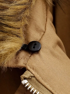 Close-up of brown faux fur collar, khaki twill fabric, black button and metal zipper