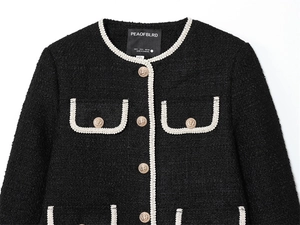 Détail de la veste en tweed avec tresses contrastées et boutons dorés en relief