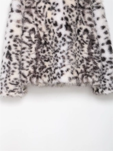 Close-up detail of soft faux fur fabric with grey leopard print on a warm winter jacket
