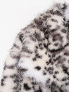 Macro detail of high-quality snow leopard print faux fur texture on fashion jacket
