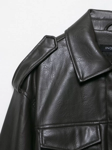 Detail of dark faux leather jacket featuring lapels, shoulder epaulettes, and chest pockets