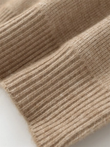 Close-up of khaki knitted sweater featuring ribbed cuffs and soft fuzzy texture