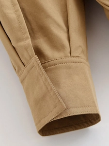 Detailed close-up of khaki jacket cuff with high-density twill fabric and double stitching