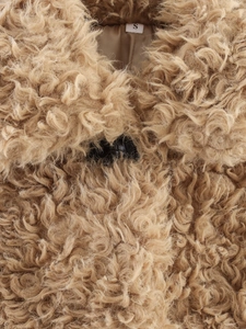 Close-up of khaki brown teddy coat showing dense spiral fur texture and S size label