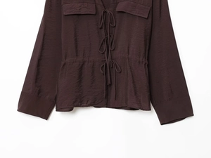 Detail of chocolate brown long sleeve blouse with drawstrings and chest pockets