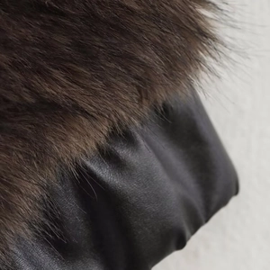 Veste en fausse fourrure marron foncé et cuir noir avec une coupe ample et élégante