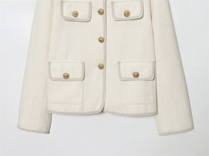 Détails de la veste en tweed crème avec boutons dorés tête de lion et texture