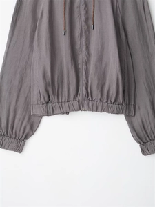 Close-up of gray hooded bomber jacket with adjustable woven drawstrings and elastic hems