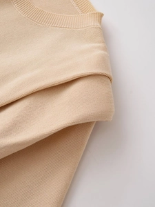 Close-up of ribbed crewneck and fine knit texture on beige short sleeve sweater