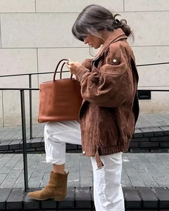 Details einer dunkelbraunen Wildlederjacke mit Vintage-Revers und Metalldruckknöpfen