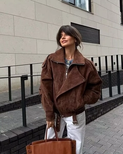 Detail einer braunen Bikerjacke aus Wildlederimitat mit breitem Revers und Gürtelschnalle