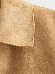 Macro detail of camel faux leather jacket featuring premium contrast stitching texture