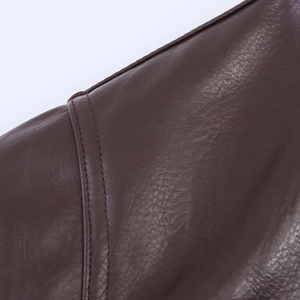 Macro view showing high-quality double stitching and texture of brown faux leather jacket