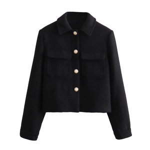 Detail of cropped black jacket with golden metal buttons and classic flap pockets