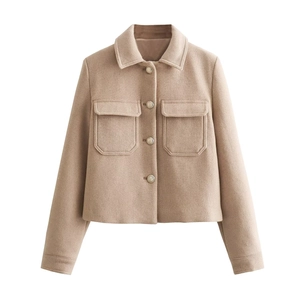 Detail of khaki cropped jacket showing metallic buttons and flap pockets texture
