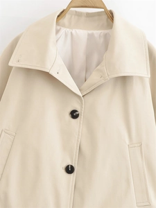 Close-up of beige waterproof trench coat featuring lapel collar and marble-textured buttons