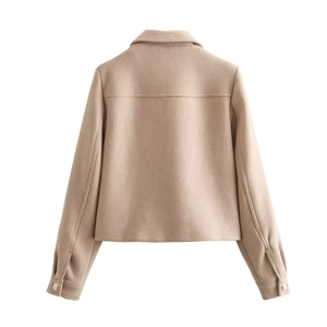 Back view of oatmeal cropped jacket showing yoke seam detail and metal buttoned cuffs