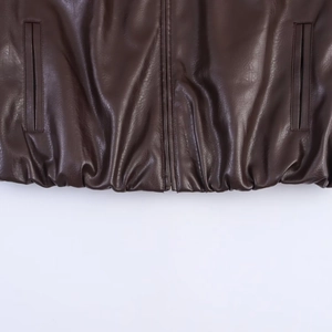 Detail of dark brown faux leather bomber jacket with metal zipper and elastic hem