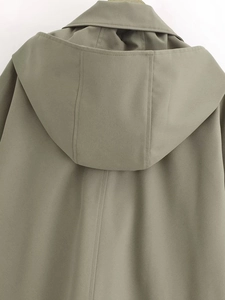 Detail view of the large hood and stitching on the back of an olive green cape jacket