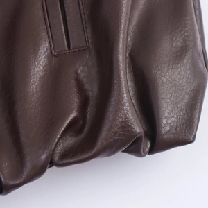 Close-up of deep brown faux leather jacket texture with precise stitching details