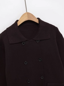 Détail de la maille épaisse et des boutons croisés sur le cardigan marron foncé