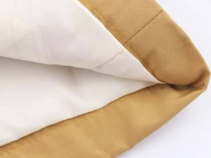 Close-up of khaki canvas fabric texture with neat yellow stitching and white lining