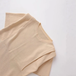 Women's beige crew neck knit top with shoulder pads in a minimalist solid color style