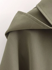 Detail of olive green hooded jacket showing fine stitching and twill cotton texture