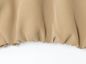 Close-up of khaki jacket hem featuring elastic ribbed cuffs and twill cotton texture