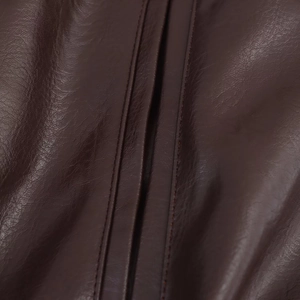 Macro detail of high-quality faux leather texture and precise stitching on pilot jacket