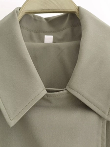 Detailed close-up of olive green trench jacket collar showing twill fabric texture