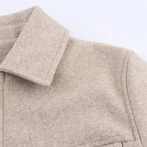 Detailed close-up showing the lapel construction and wool texture of an oatmeal jacket