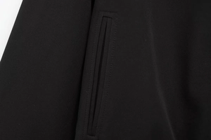 Macro view of welt pocket detail on high-quality black woven puffer jacket for women