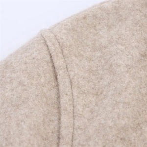 Macro detail of the beige wool-like fabric texture and fine stitching on the jacket