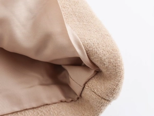 Detailed view of the beige wool blend jacket hem showing refined stitching and silk lining