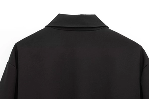 Detail of the clean stitching and collar construction on a black puffer jacket