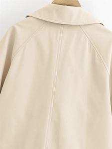Detail view of beige trench coat back featuring raglan sleeves and premium stitching