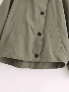 Detail of army green jacket with single-breasted buttons and two vertical flat pockets
